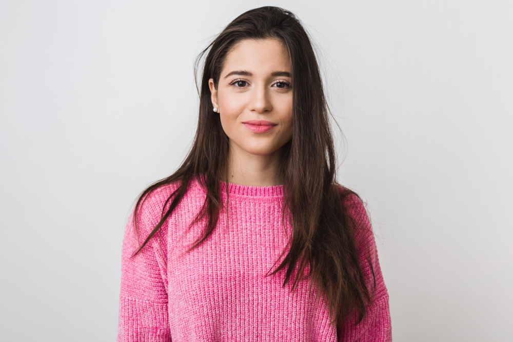 Woman in pink sweater smiling at the camera against a white background, advertising payday loans.